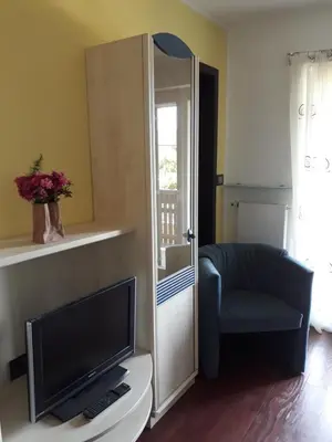 a living room with a television and a chair at GRETL - Residence in Parcines