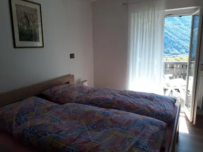 a bedroom with a bed and a view of a balcony at GRETL - Residence in Parcines