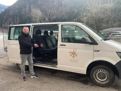 a man standing in front of a white van at Hotel Pontives in Ortisei