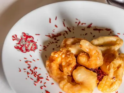 a white plate of shrimp with sprinkles on it at Hotel Pontives in Ortisei