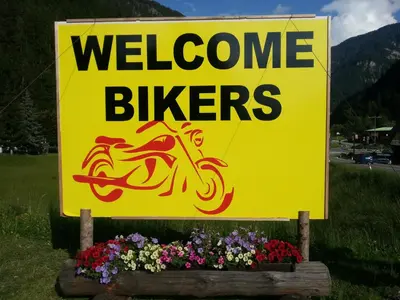 a yellow welcome sign with flowers in front of it at Hotel Pontives in Ortisei