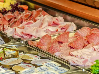 a display case with many different types of meat at Hotel Pontives in Ortisei