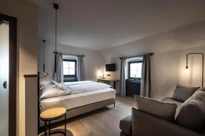 a bedroom with a bed and a couch at Ansitz Fonteklaus in Chiusa