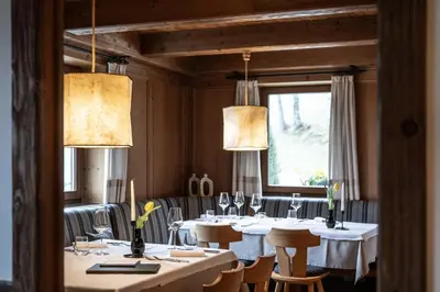a dining room with white tables and chairs and lights at Ansitz Fonteklaus in Chiusa