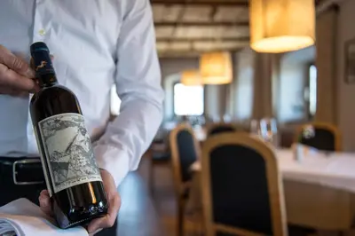 a man is holding a bottle of wine at Ansitz Fonteklaus in Chiusa