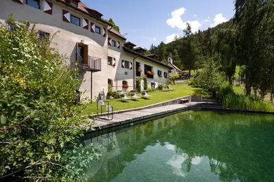 a house with a pool of water in front of it at Ansitz Fonteklaus in Chiusa