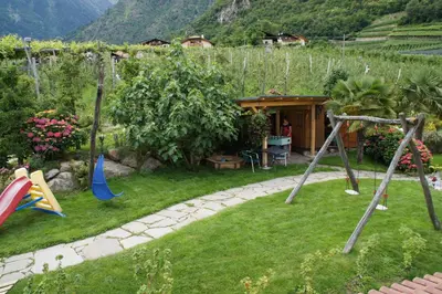 a garden with a playground and a house at Oberangerhof in Lagundo