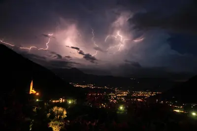 a lightning storm over a city at night at Oberangerhof in Lagundo