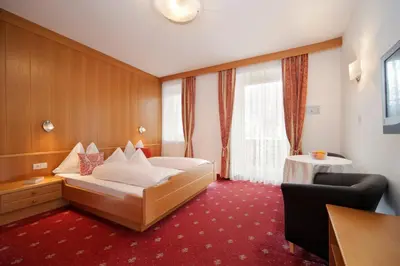 a hotel room with a bed and a table at Garni Unterhaslerhof in Merano