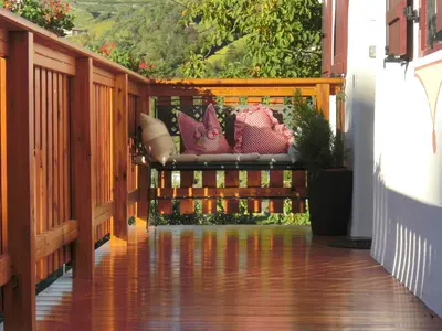 a porch with a bench with pillows on it at Garni Unterhaslerhof in Merano