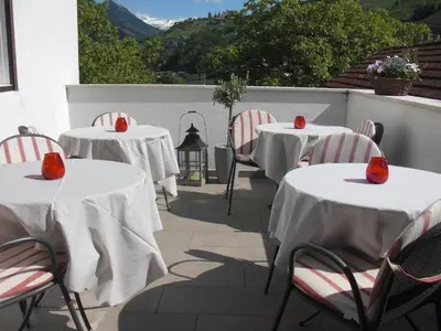 a row of tables with red seats on a patio at Garni Unterhaslerhof in Merano