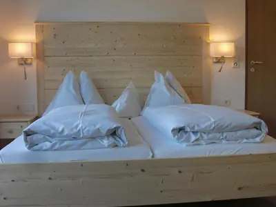 a bed with white sheets and pillows on it at Garni Unterhaslerhof in Merano