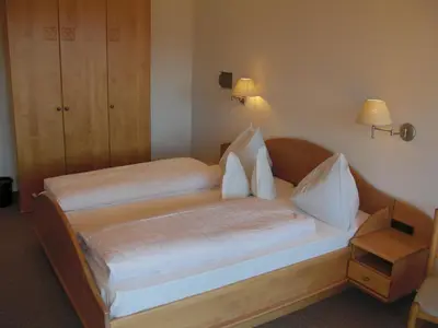 a bedroom with two beds with white sheets and pillows at Garni Unterhaslerhof in Merano
