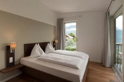 a bedroom with a bed and a large window at Apparthotel Calma in Cermes