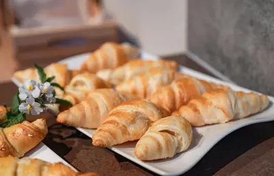 a plate of croissants and other pastries on a table at Apparthotel Calma in Cermes
