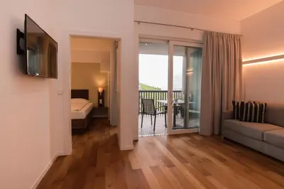 a living room with a couch and a bed and a balcony at Apparthotel Calma in Cermes