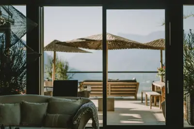 a living room with a couch and a view of the ocean at Hotel KÜGLERHOF in Tirolo