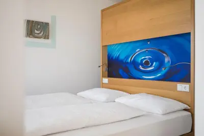 two beds in a room with a painting on the wall at Residence Aqualis in Marlengo