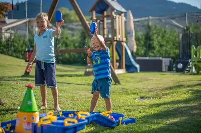 two young boys playing with a toy in a playground at Hotel Sonnenhof in Lana