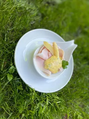 a white plate with food on the grass at Hotel Sonnenhof in Lana