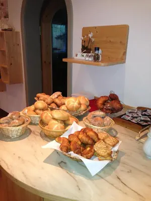 a table with many different types of breads and pastries at Pension Lärchenhof in Naturno