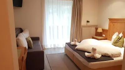 a bedroom with two stuffed animals on a bed at Pension Lärchenhof in Naturno