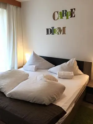 a large bed with white sheets and pillows on it at Pension Lärchenhof in Naturno