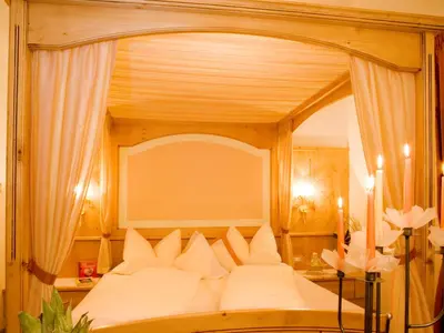 a bedroom with a large canopy bed with white pillows at Pension Verdinserhöhe in Schenna