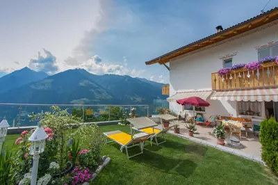 a house with a garden with a view of mountains at Pension Verdinserhöhe in Schenna