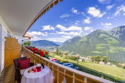 a balcony with a table and a view of mountains at Pension Verdinserhöhe in Schenna