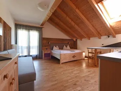 a bedroom with a bed and a table in a room at Apart Residence Rautal ***S in San Vigilio Di Marebbe