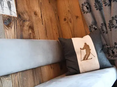 a bed with a pillow with a silhouette of a skier at Apart Residence Rautal ***S in San Vigilio Di Marebbe