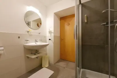 a bathroom with a sink and a shower at Apart Residence Rautal ***S in San Vigilio Di Marebbe