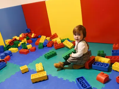 a young child playing with toy blocks in a room at Apart Residence Rautal ***S in San Vigilio Di Marebbe