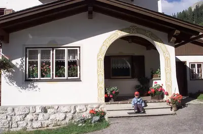 a small statue sitting on the steps of a house at Garni Margherita in Corvara in Badia