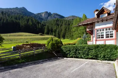 a house with a bunch of logs in a field at Kristiania in Campitello