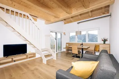 a living room with a couch and a tv and a table at Baumgartnerhof MÜLLER THURGAU in Cortaccia