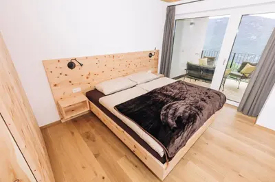 a bedroom with a bed and a large window at Baumgartnerhof MÜLLER THURGAU in Cortaccia