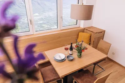 a dining room with a wooden table with flowers on it at Baumgartnerhof MÜLLER THURGAU in Cortaccia