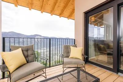 a balcony with two chairs and a view at Baumgartnerhof MÜLLER THURGAU in Cortaccia
