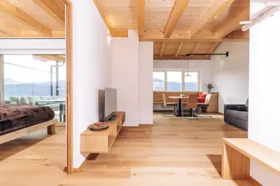 a room with a bed and a tv and a living room at Baumgartnerhof BLAUBURGUNDER in Cortaccia