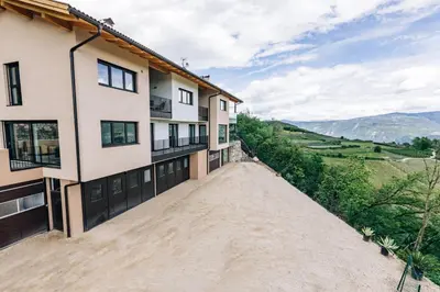an empty dirt road in front of a building at Baumgartnerhof BLAUBURGUNDER in Cortaccia