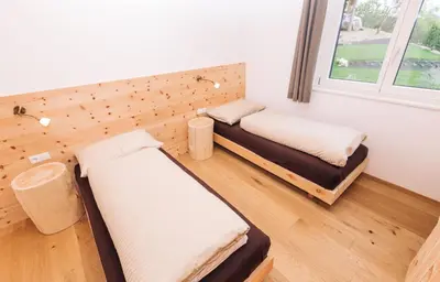a room with two beds and a window at Baumgartnerhof BLAUBURGUNDER in Cortaccia