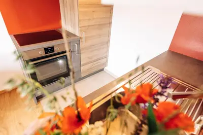 a kitchen with a stove and a vase of flowers at Baumgartnerhof BLAUBURGUNDER in Cortaccia