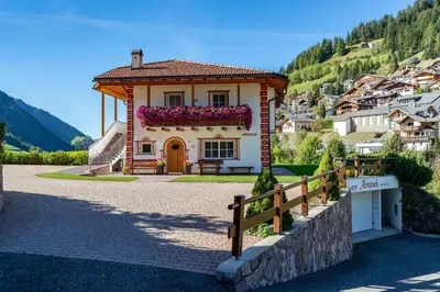 a small house with a fence in front of a mountain at Artitsch in Santa Cristina in Val Gardena