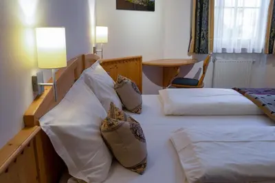 two twin beds in a room with a table at Artitsch in Santa Cristina in Val Gardena