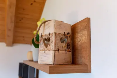 a wooden box with two hearts on a shelf at Ferienwohnungen Oberweier in Merano