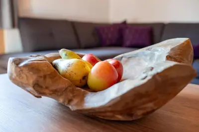 a wooden bowl of fruit on a table at Ferienwohnungen Oberweier in Merano