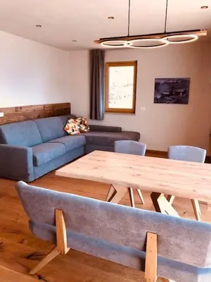 a living room with a table and a blue couch at Ferienwohnungen Oberweier in Merano