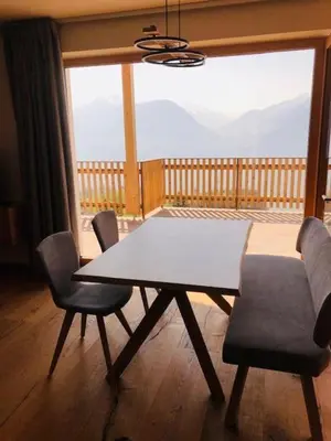 a table and chairs in a room with a large window at Ferienwohnungen Oberweier in Merano
